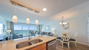 A modern kitchen with granite countertops, stainless steel appliances, and a view to the outside. - Amazing Gulf Front Views at Cabana Club 307 (Destin)