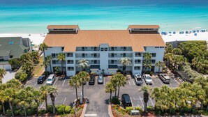 A hotel with a parking lot, a beach view, and palm trees. - Amazing Gulf Front Views at Cabana Club 307 (Destin)