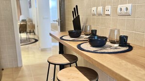 Una cocina con encimera de madera, dos taburetes y un bloque para cuchillos.