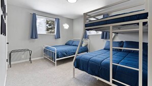 A bunk bed room with a window, a small table, and a ceiling light. - Rock n Roll! DT 2bd home! Walk to beach, bars&more (Port Sanilac)