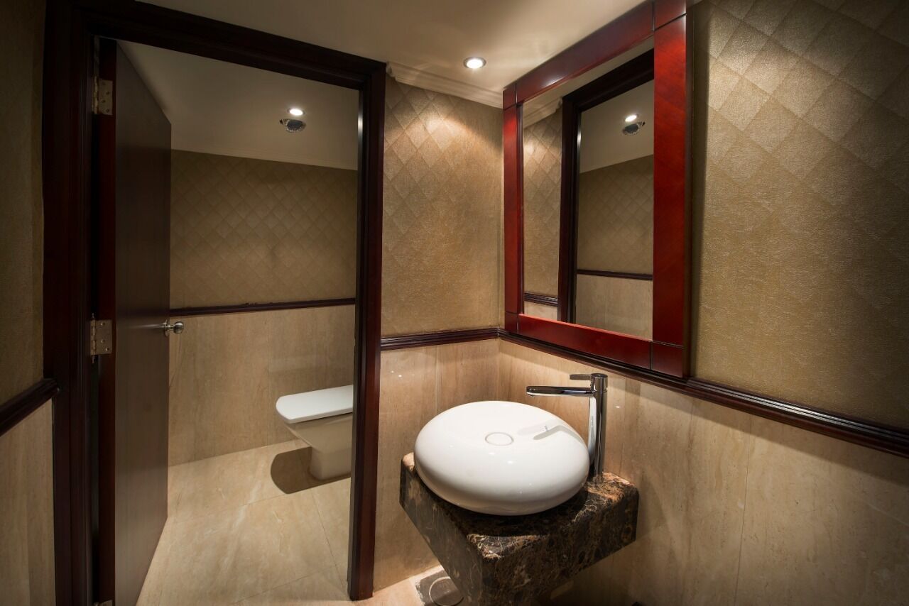 Een badkamer met een witte wasbak, een spiegel en een toilet.