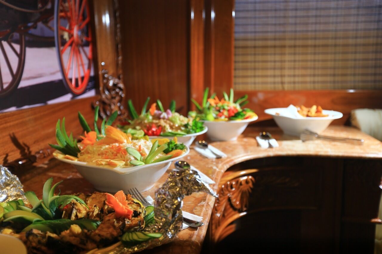 Een eettafel met diverse gerechten, waaronder salades en zeevruchten, in een restaurant.
