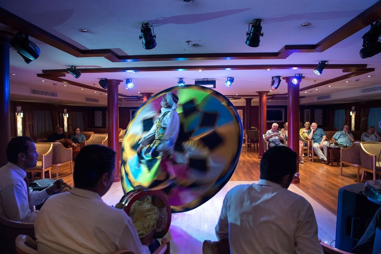 A conference room with a large, colorful, spherical object in the center, surrounded by seated attendees.