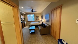 A compact hotel room with a kitchenette, a bed, a sofa, and a ceiling fan. - Perfect petite over 400 sq ft (Breckenridge)