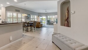 A spacious living area with a dining table, sofa, and a large window.