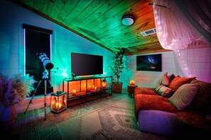 Una sala de estar acogedora con televisión, telescopio y chimenea.