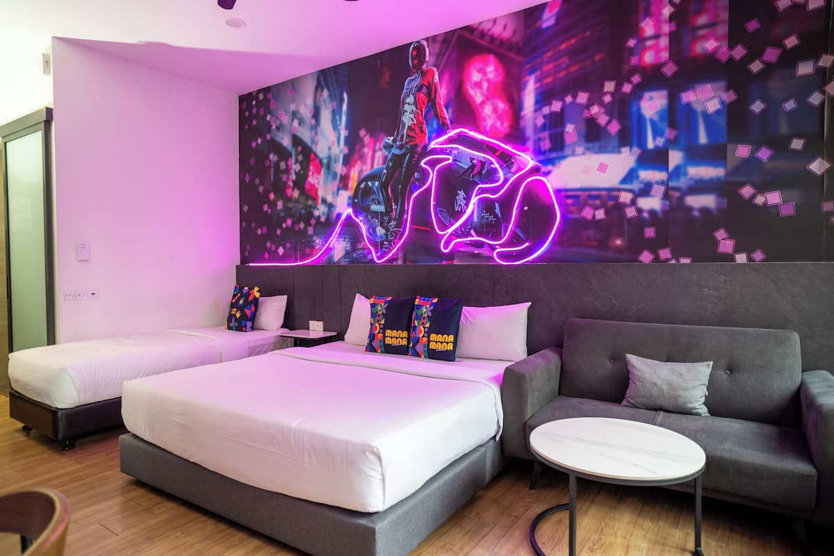 Habitació d'hotel moderna amb un llit gran, un sofà i una taula petita.