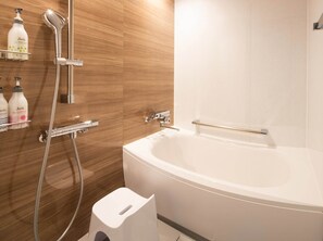 A modern bathroom with a freestanding bathtub, a handheld showerhead, and toiletries on a shelf. - LagentStay Shin-Sapporo (Sapporo)