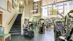 Una palestra con attrezzi per esercizi, una scala e uno specchio.
