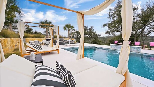 A poolside area with lounge chairs and a canopy. - Sleeps 20 , Game Barn, Pool, Hot Tub, Luxe Retreat (Dripping Springs)