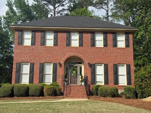 A two-story brick house with a central entrance, multiple windows with shutters, and a front porch. - 4 bedroom Masters Rental 5 miles from Augusta National (Martinez)