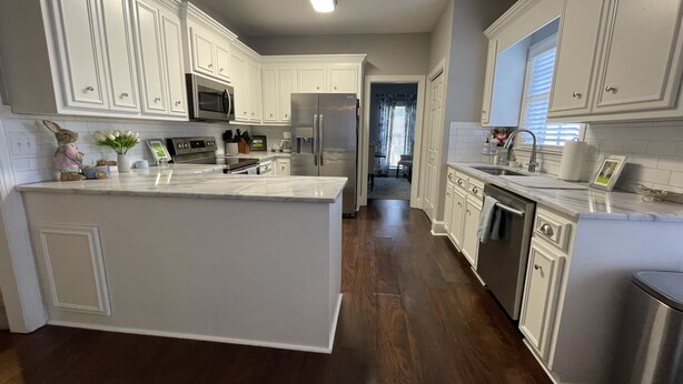 A modern kitchen with white cabinetry, stainless steel appliances, and a large island. - 4 bedroom Masters Rental 5 miles from Augusta National (Martinez)