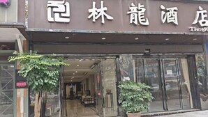 A hotel entrance with glass doors, indoor plants, and a red carpet leading to the entrance. - Linlong Hotel in Yinjiang (Yinjiang)