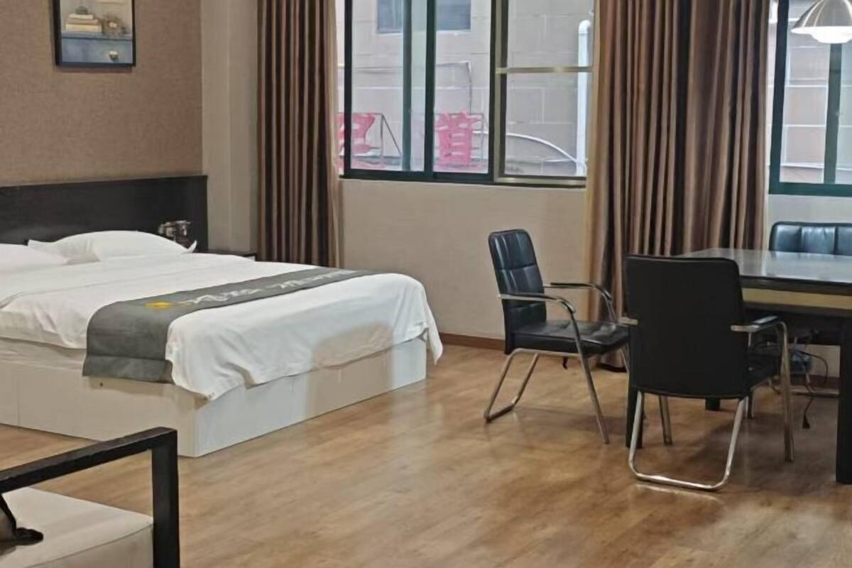A hotel room with a bed, a desk, and a chair.