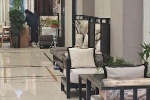 Un hall de hotel con un área de descanso, una mesita y una planta en maceta.