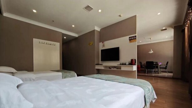 A hotel room with two beds, a desk, a flat-screen TV, and a seating area. - Linlong Hotel in Yinjiang (Yinjiang)