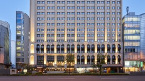 Un hotel de varios pisos con una fachada simétrica, ventanas amplias y una entrada central con dosel.