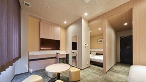Una habitación de hotel moderna con kitchenette, una cama, un escritorio y una zona de estar.
