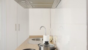 A modern kitchen with white cabinets, stainless steel appliances, and a wooden countertop. - Rentalsevilla Living La Alameda (Sevilla)