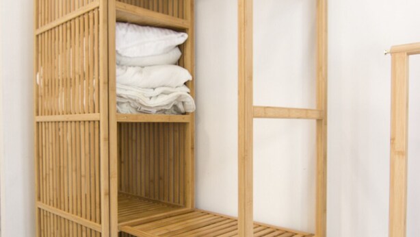 A wooden shelf unit with folded towels. - Rentalsevilla Vive el Salvador (Sevilla)