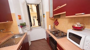 A compact kitchen with a gas stove, a microwave, and a sink.