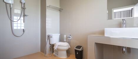 A modern bathroom with a toilet, bidet, and shower unit.