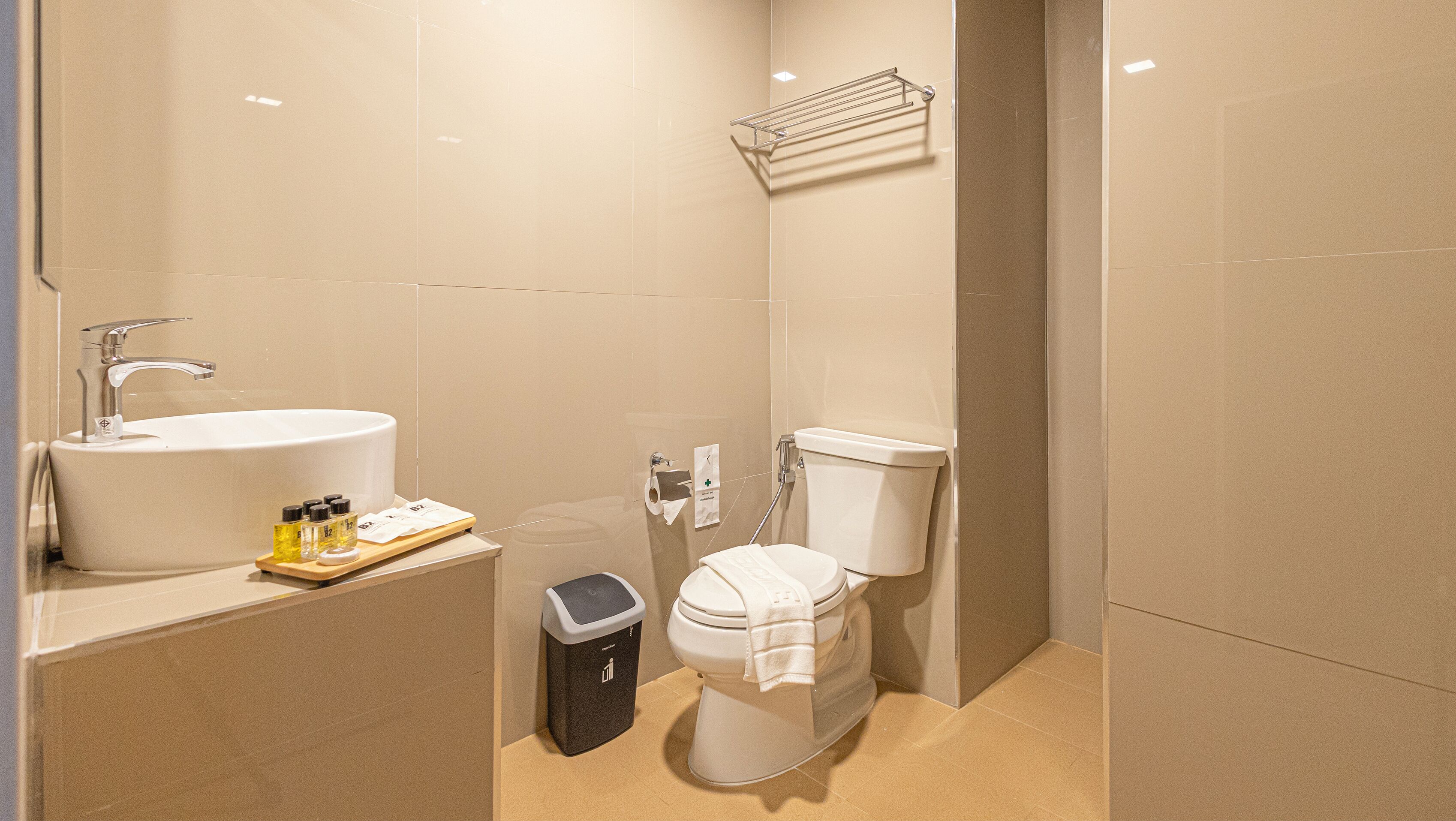 A modern bathroom with a sink, toilet, and trash bin.
