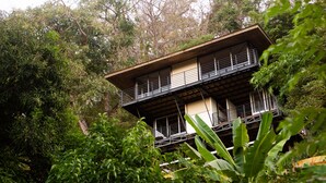 Un edificio a più piani con balconi, immerso nel verde.