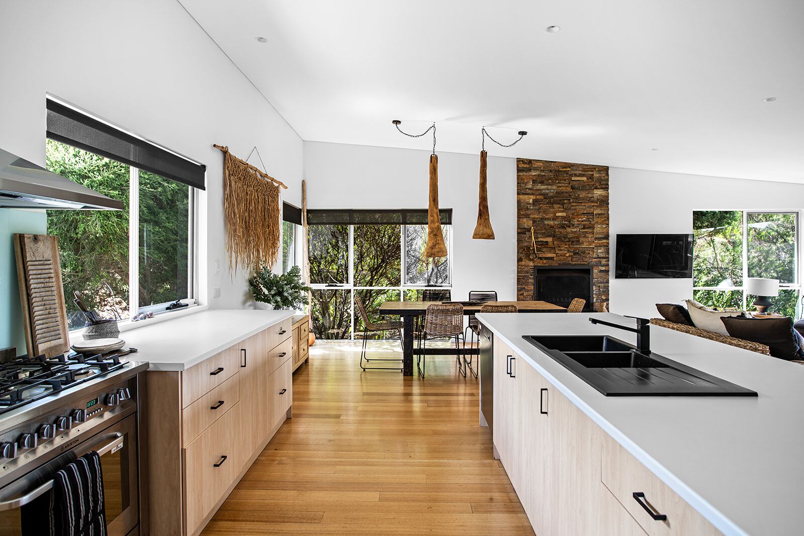 Una cucina moderna con una grande isola, mobili in legno e una parete decorata con pietra.