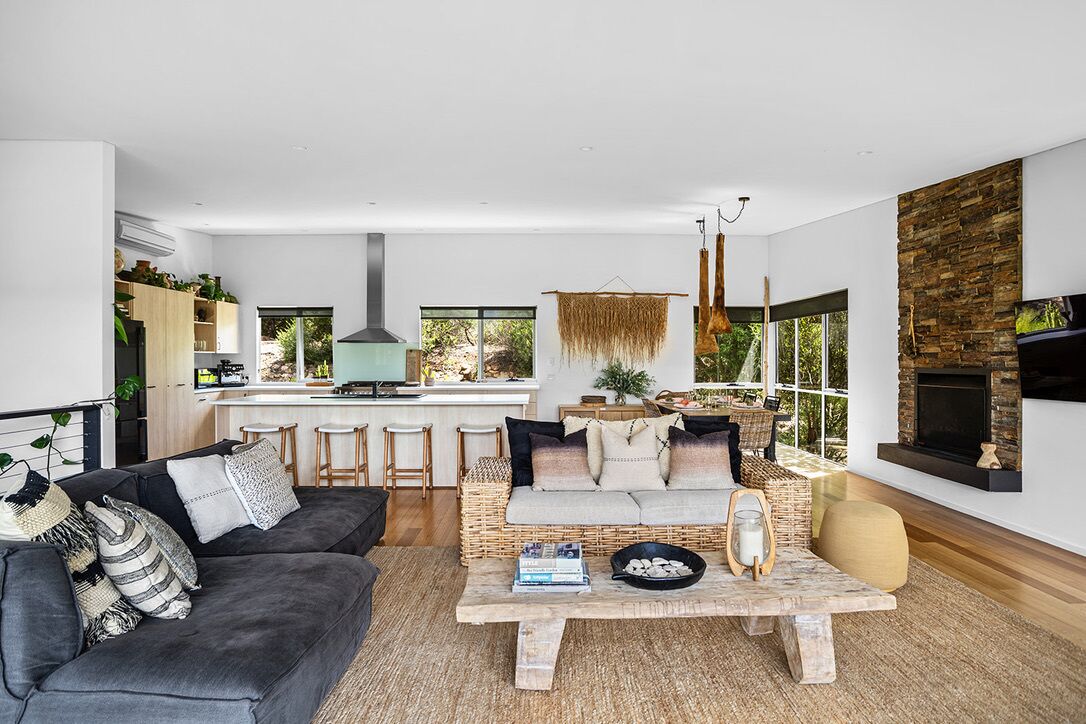 A modern living room with a sofa, coffee table, and a fireplace.