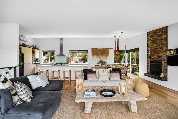 A modern living room with a sofa, coffee table, and a fireplace.