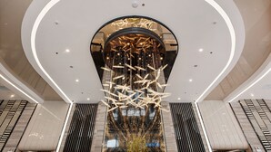 A modern interior with a central circular design, a reflective floor, and a unique hanging light fixture. - Muong Thanh Luxury Cao Bang Hotel (Thuc Phan)