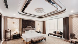 A luxurious bedroom with a large bed, a nightstand, a bench, and a chair. - Muong Thanh Luxury Cao Bang Hotel (Thuc Phan)