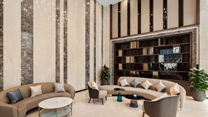 A spacious living room with a large sectional sofa, a coffee table, and a bookshelf. - Muong Thanh Luxury Cao Bang Hotel (Thuc Phan)