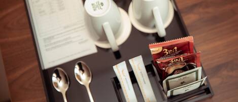Un plateau avec deux tasses, deux cuillères et une boîte de sachets de thé.