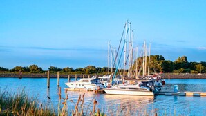 Un puerto deportivo con barcos amarrados, agua tranquila y cielo despejado.