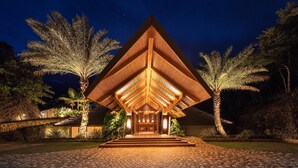 A building with a triangular roof structure and a paved entrance area. - Manami Resort (Sipalay)