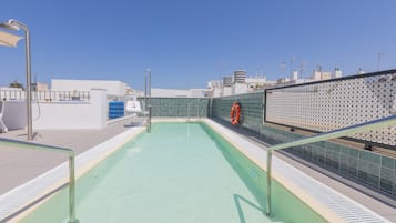 Una piscina al aire libre de temporada, sombrillas