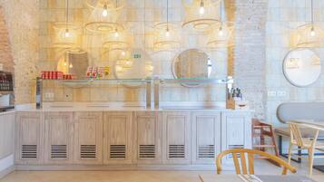 Une cuisine moderne avec des meubles en bois, un plan de travail en verre et des luminaires suspendus.