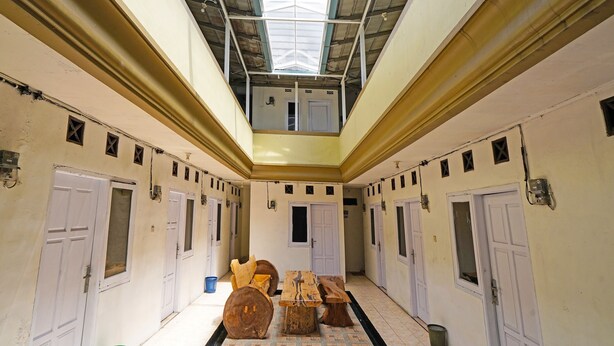 Un pasillo con varias puertas, un tragaluz y muebles de madera.