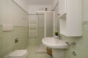 A bathroom with a toilet, sink, and shower. - Porto Letizia Torino 2A, Porlezza, Italy (Porlezza)