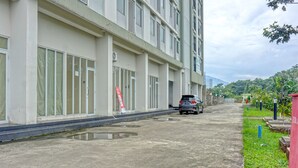 A multi-story building with large windows and a car parked in front. - Hotel O Skyland Bogorienze Apartment (Bogor)