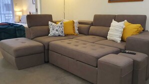Un sofá modular con diversas opciones de asientos y un control remoto encima.