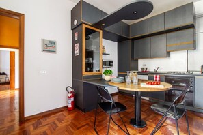 Une cuisine moderne avec un coin repas, un extincteur et un panneau indiquant la présence de lait frais.
