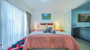 A hotel room with a bed, a bedside table with lamps, a painting on the wall, and a sofa. - Luxurious oasis 10mins to Perth DT, Elizabeth Quay & PCEC (Perth)