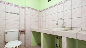 Een badkamer met toilet, wastafel en groene wanden.