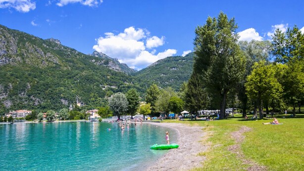 A lakeside view with a grassy area, trees, and a mountain in the background. - Porto Letizia Roma 5, Porlezza, Italy (Porlezza)