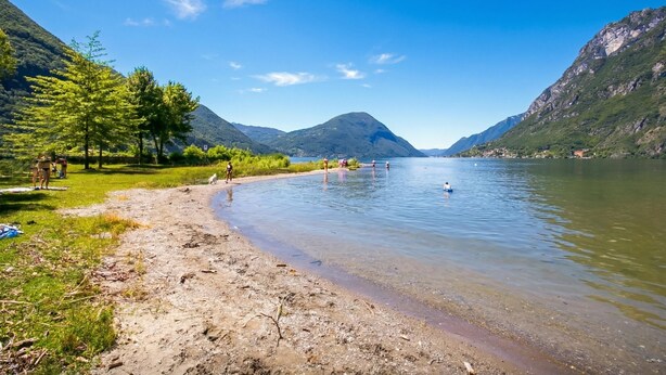 A river with people swimming and walking along the shore, surrounded by mountains and greenery. - Porto Letizia Napoli 7, Porlezza, Italy (Porlezza)