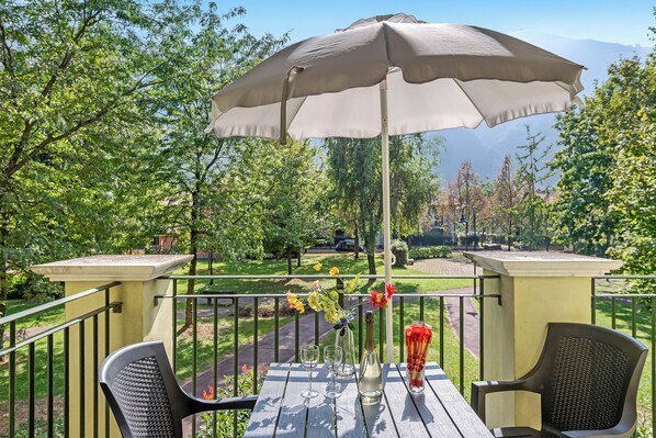 A patio with a table, chairs, and a large umbrella.