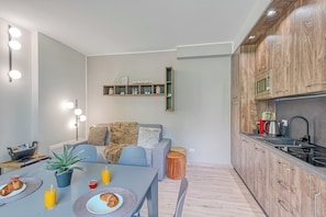A modern kitchen with wooden cabinets, a built-in microwave, and a sink. - Porto Letizia Venezia 4, Porlezza, Italy (Porlezza)